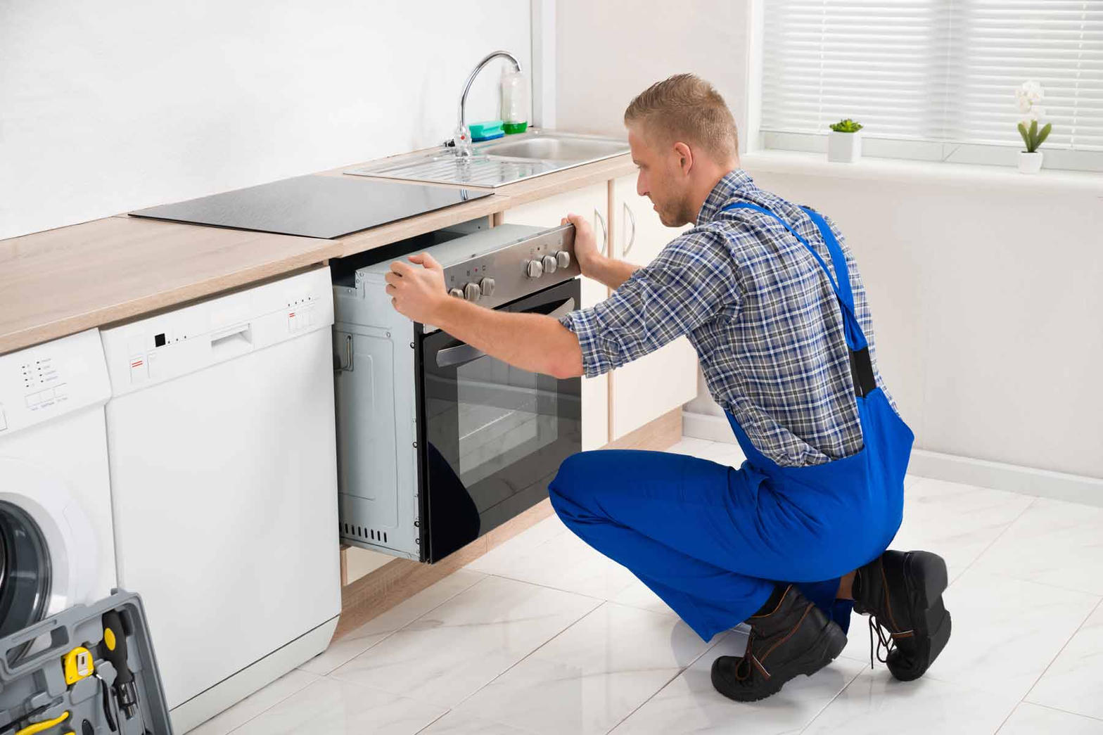 Technician sliding a range into a kitchen cabinet opening